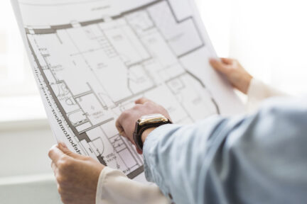 close-up-architect-s-hand-discussing-plan-blueprint