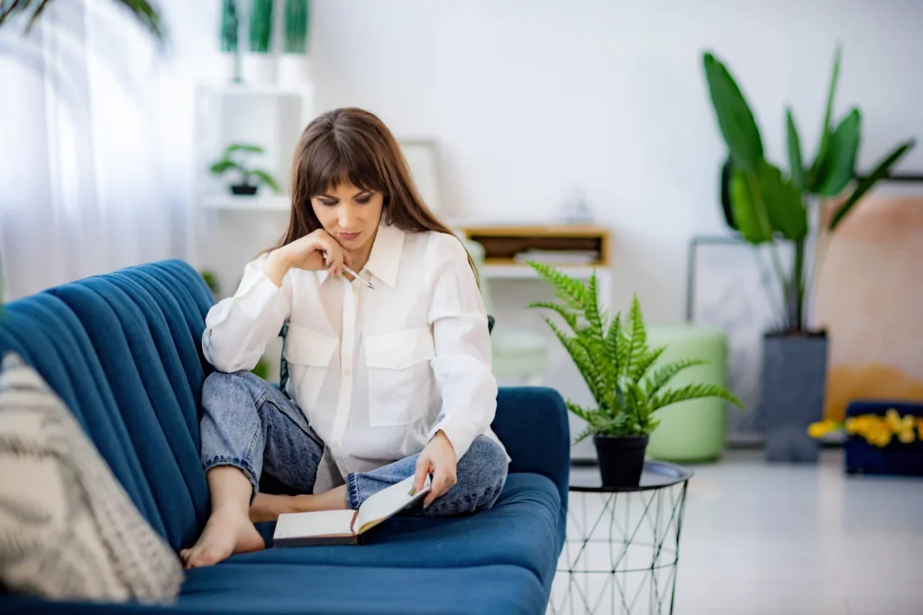 a-girl-in-a-shirt-sits-on-a-sofa-in-an-apartment-a-2023-11-27-05-30-52-utc